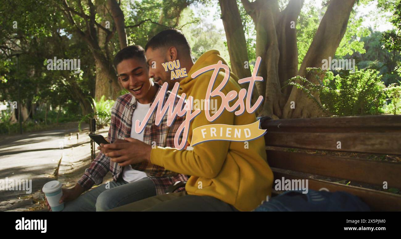 Image of my best friend text over happy biracial male friends using smartphone Stock Photo