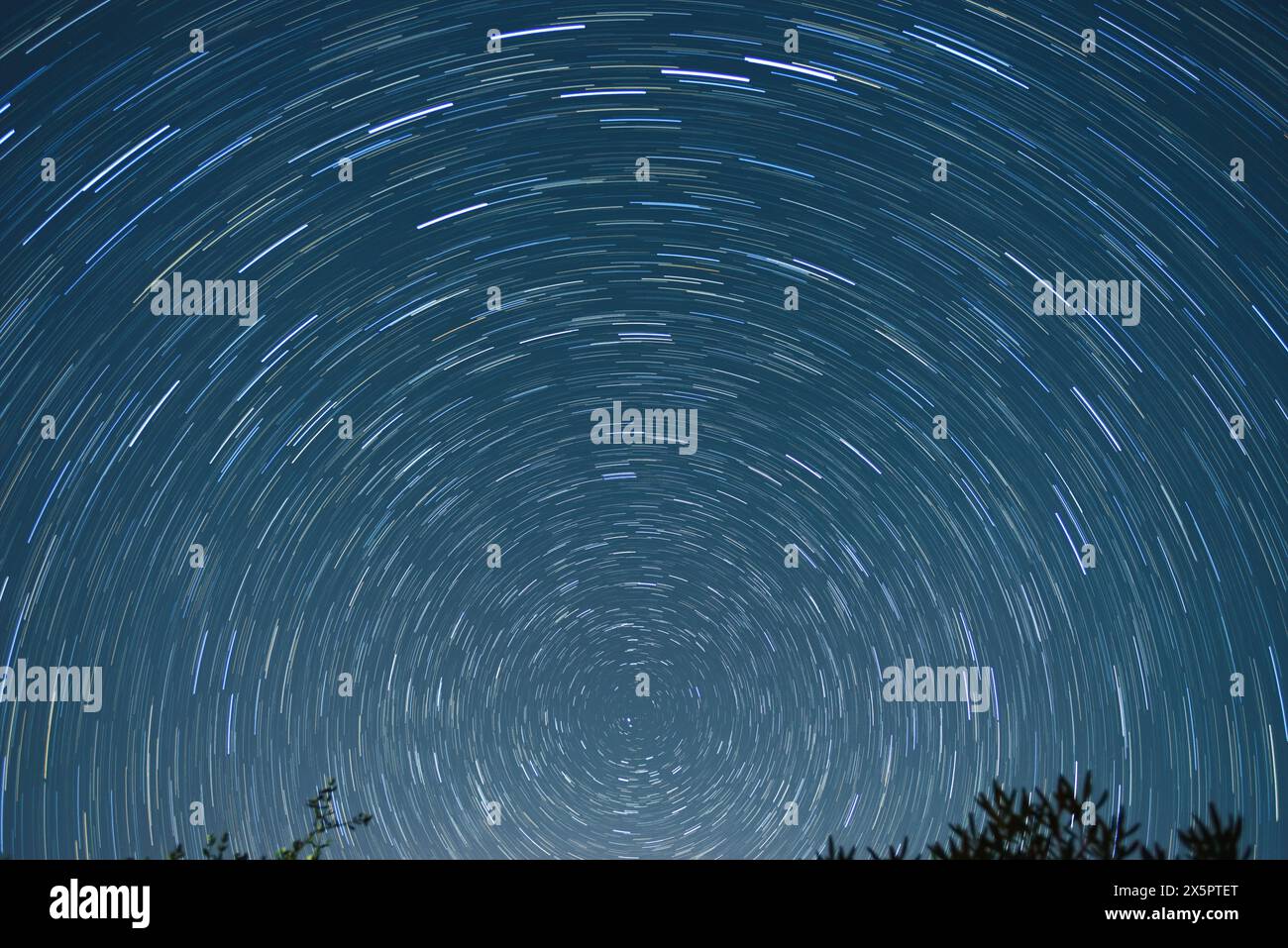 Star trail of stars moving in the night sky around the North Star. Landscape with movement of stars in the Tuscan country, time lapse Stock Photo