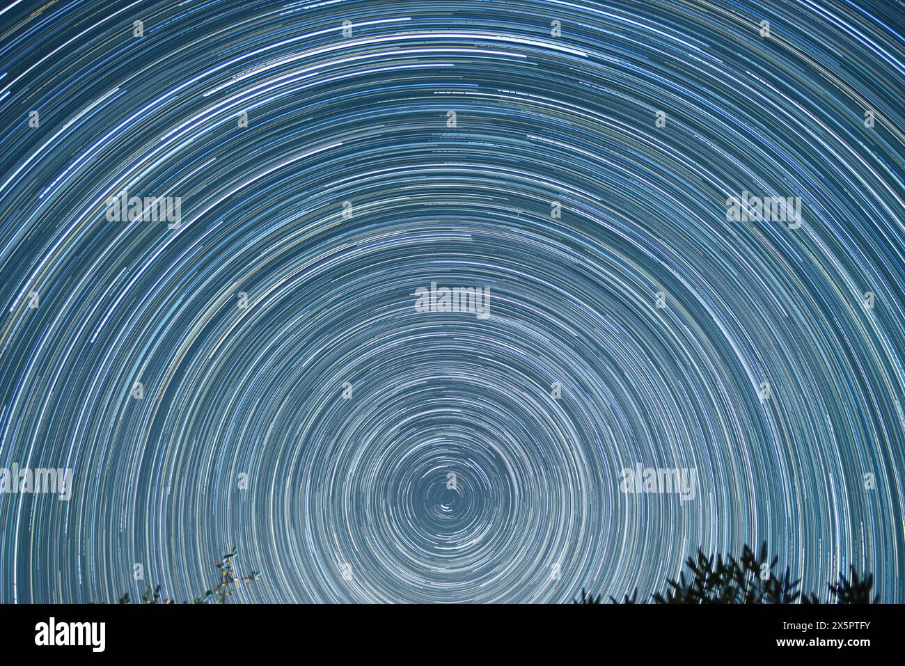 Star trail of stars moving in the night sky around the North Star. Landscape with movement of stars in the Tuscan country, time lapse Stock Photo