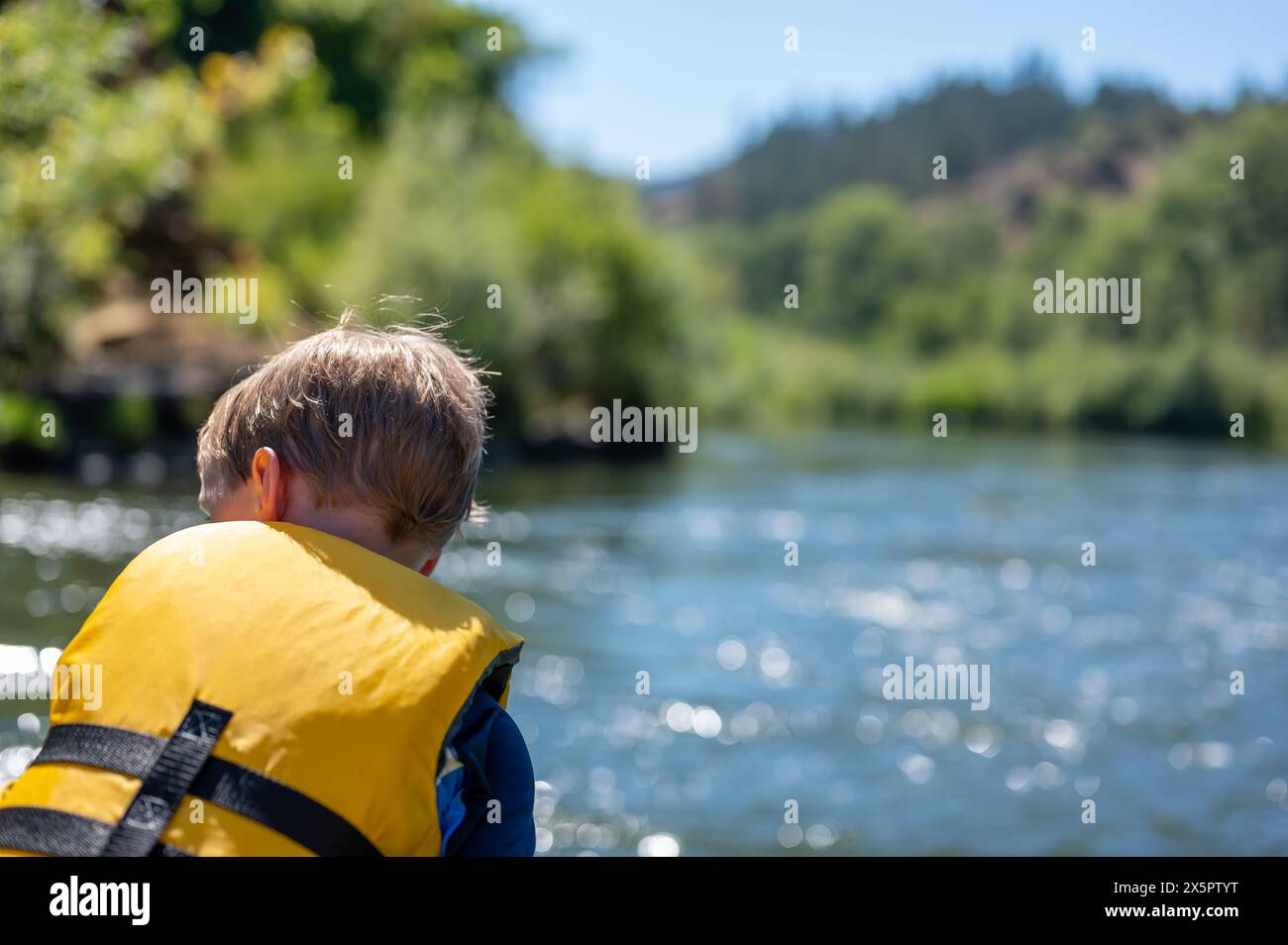 Selective focus on a child rafting down the wild and scenic Rogue River ...
