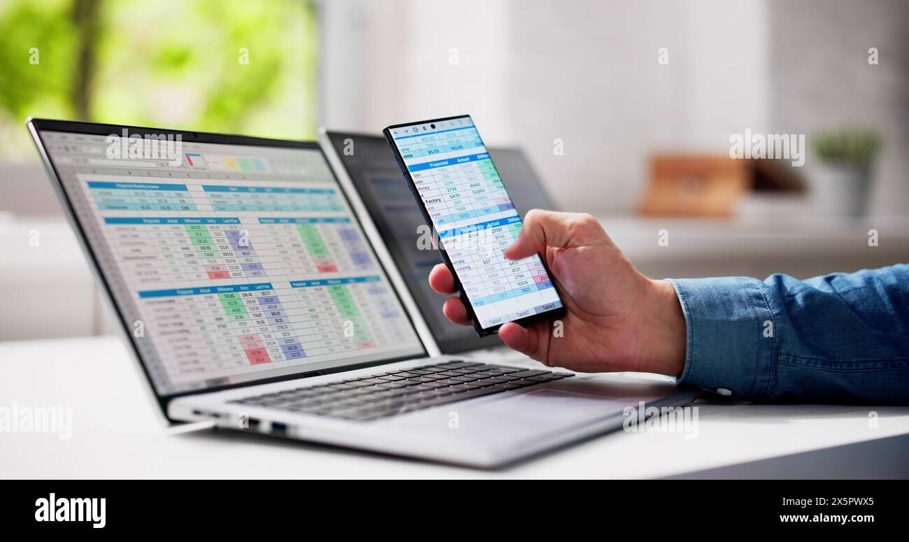 Man Using Spreadsheet Data On Laptop Computer Stock Photo