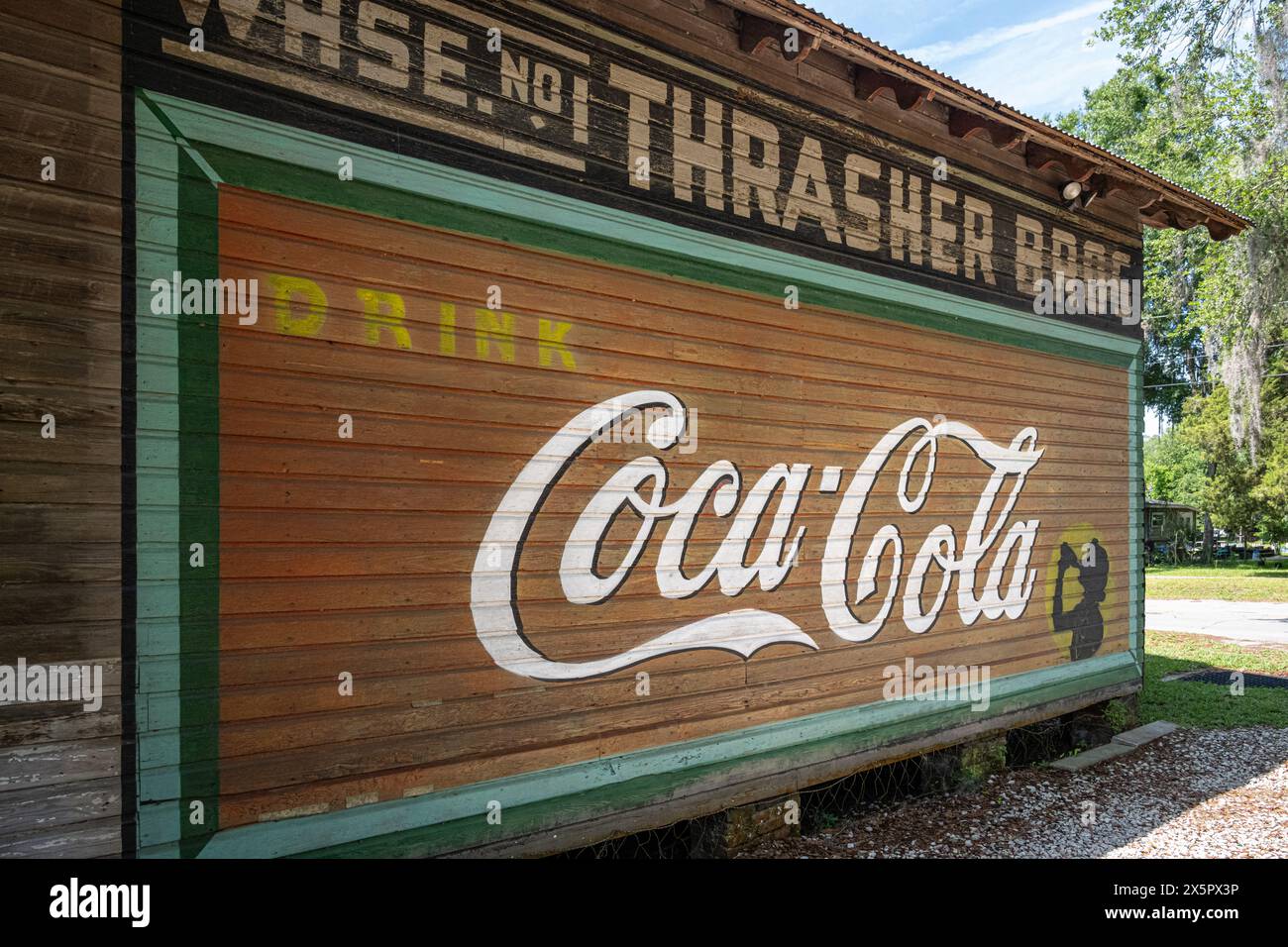 Painted Coca-Cola wall mural on the old Thrasher Brothers Warehouse at the Micanopy Historical Society Museum in historic Micanopy, Florida. (USA) Stock Photo