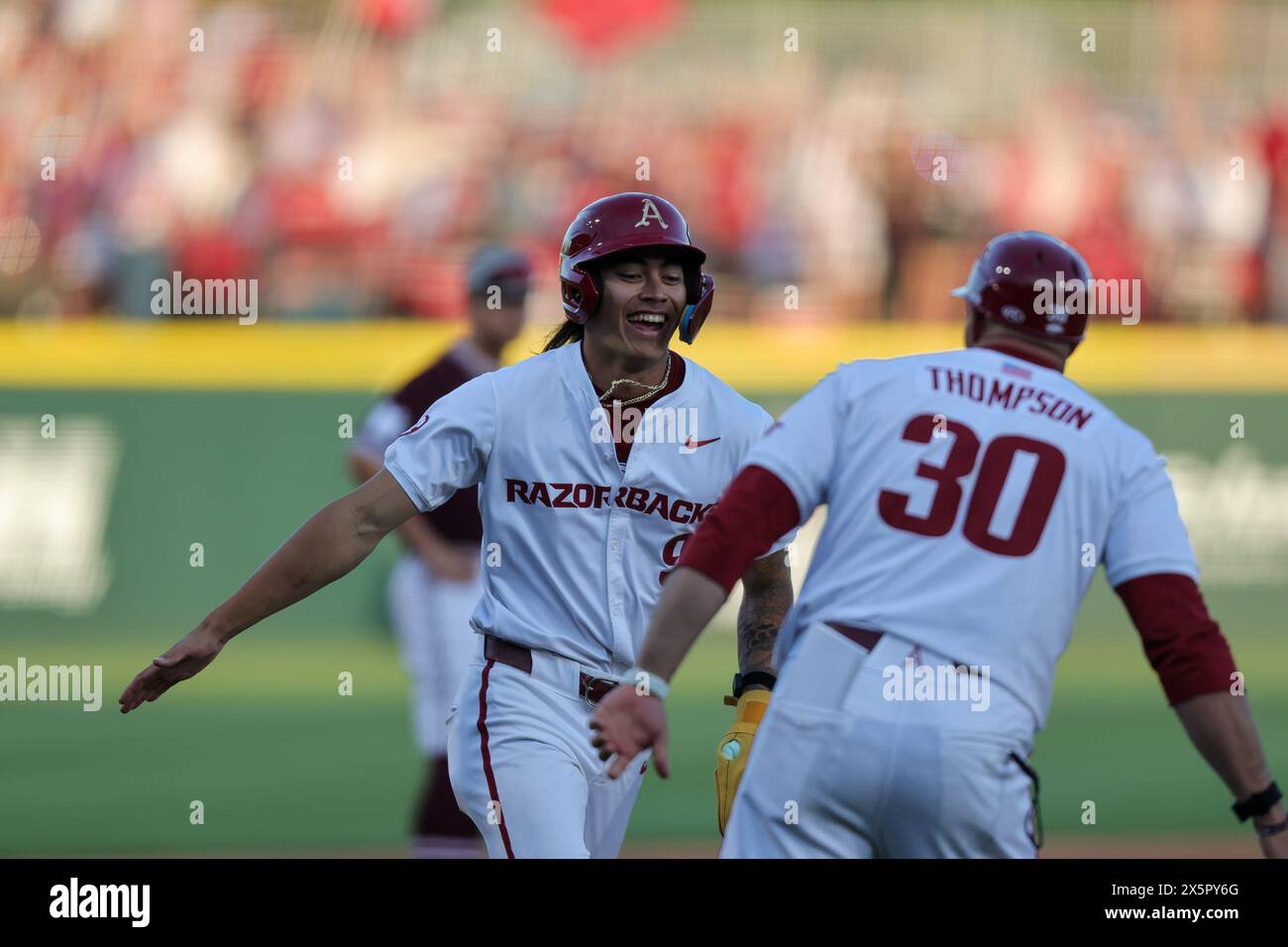 May 10, 2024: Wehiwa Aloy #9 gives a hand slap to third base coach Nate Thompson #30 as he comes around third base after being driven in by a home run. Arkansas defeated Mississippi State 7-5 in Fayetteville, AR. Richey Miller/CSM Stock Photo