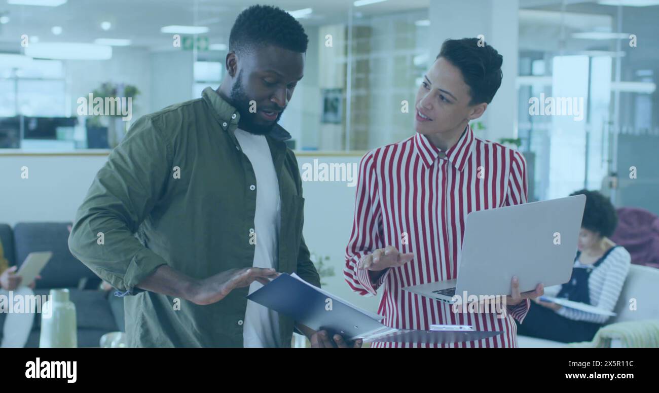 Two colleagues, one African American and one Caucasian, discussing ...