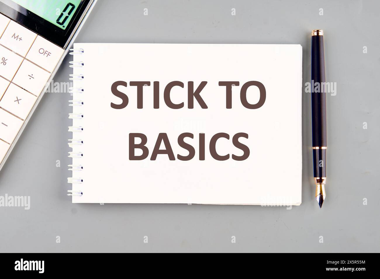 Finance and economics concept. Text STICK TO BASICS on a white notebook on a gray background Stock Photo