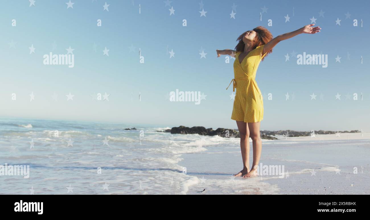 Image of stars over african american woman raising hands at beach Stock ...