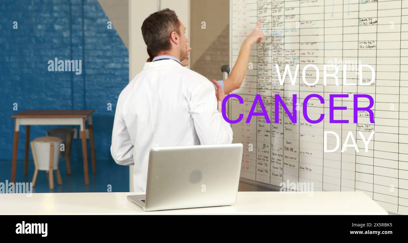 Caucasian male manager wearing lab coat, pointing at board Stock Photo