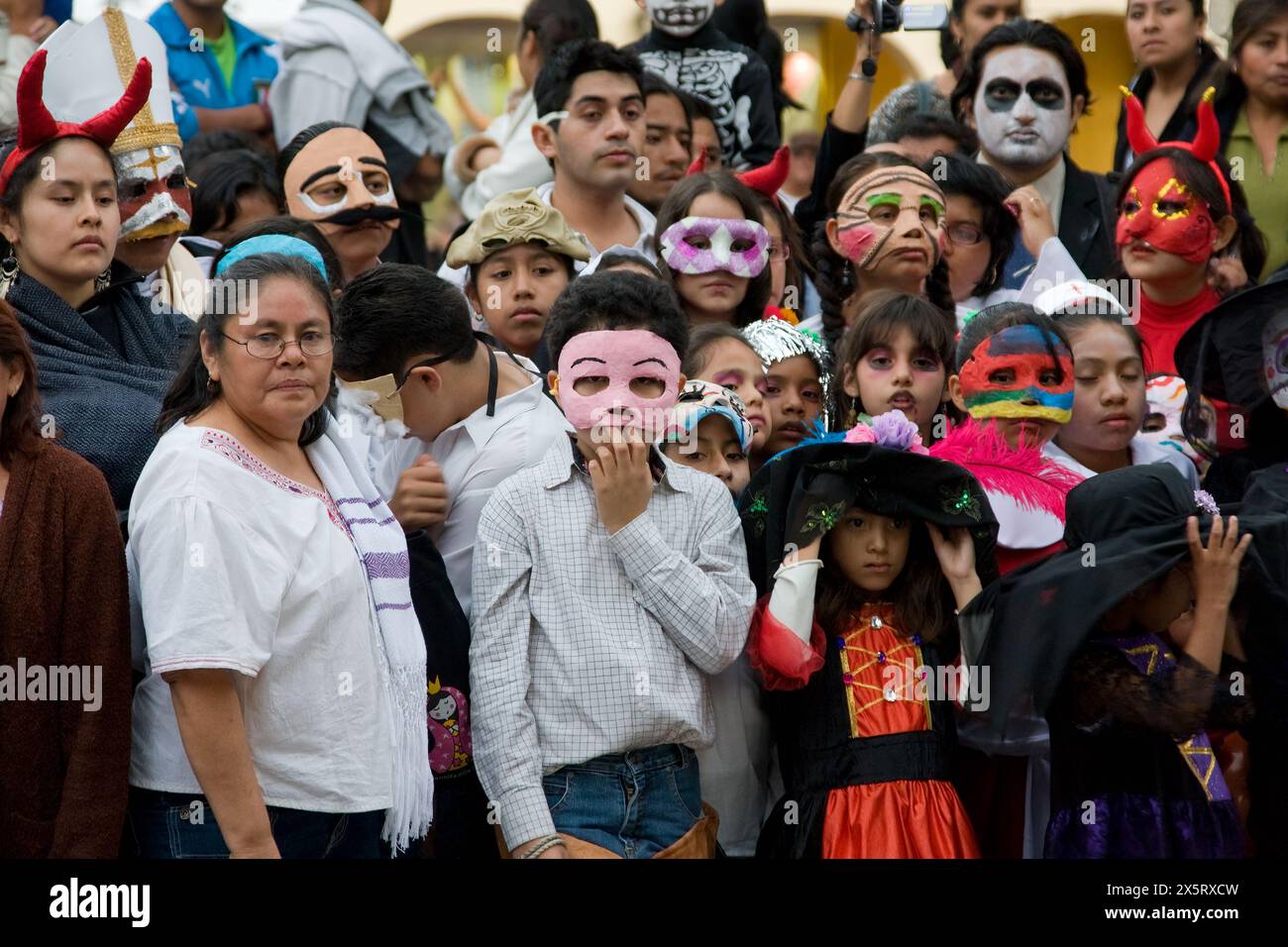 Oaxaca, Mexico.  Day of the Dead Celebrations.  Oaxacans Observing a Children's Performance, to Celebrate All Souls Day, in the Zocalo, or Town Square. Stock Photo
