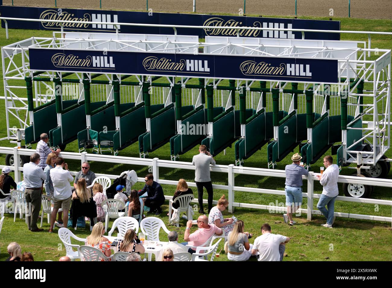 Surrey Racetrack The staring gates are towed past racegoers as they wait next to the ...