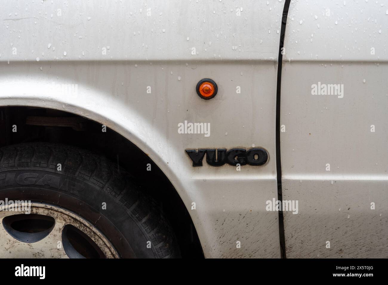 Side detail showing round indicator and logo on a classic Yugo car, made in Yugoslavia. may 2024 Stock Photo