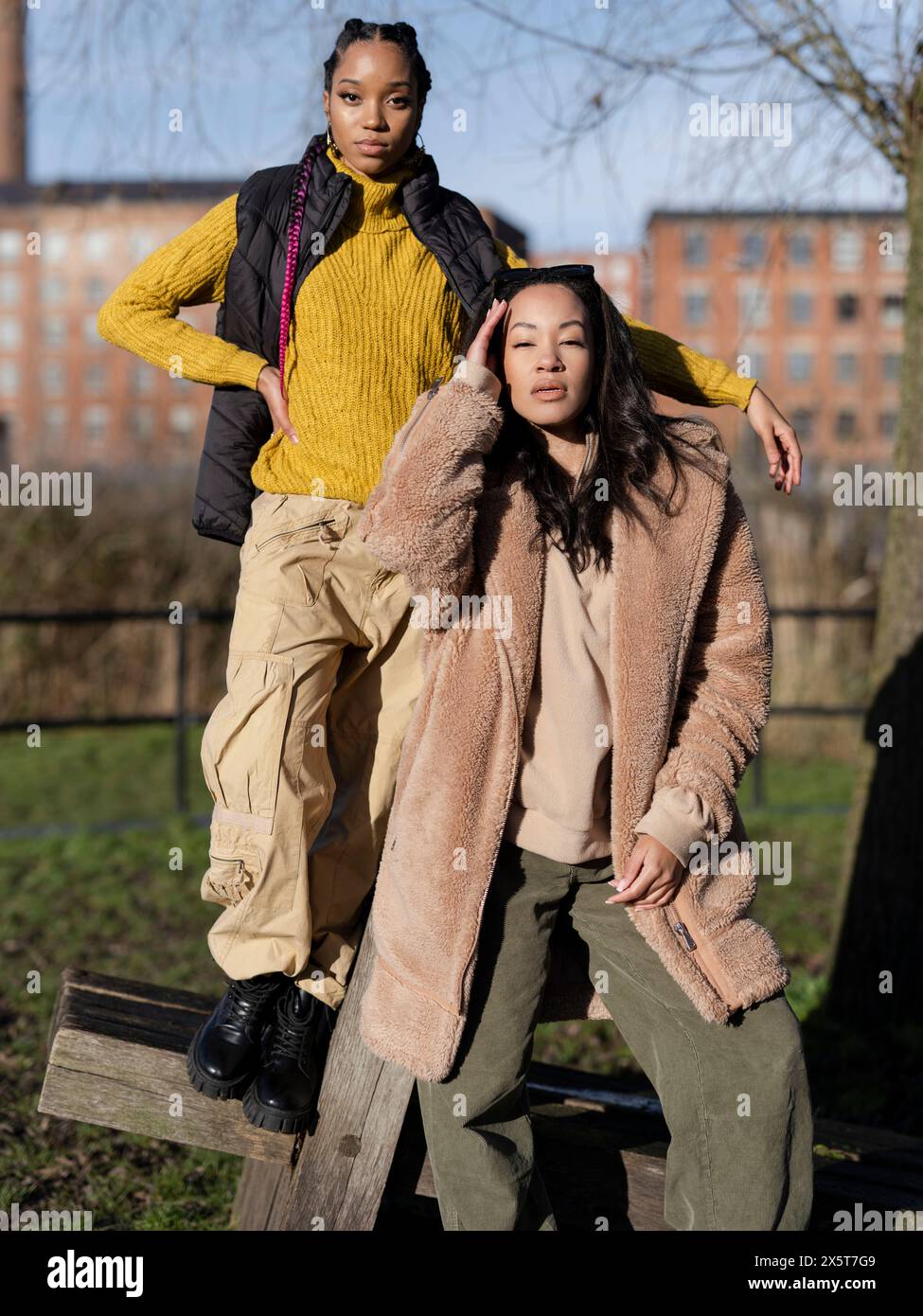 Two young women posing for portrait in park Stock Photo - Alamy