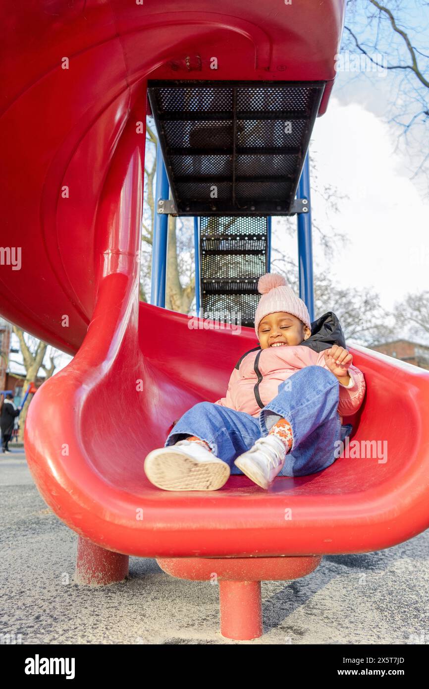 Girl (2-3) on slide in playground Stock Photo - Alamy