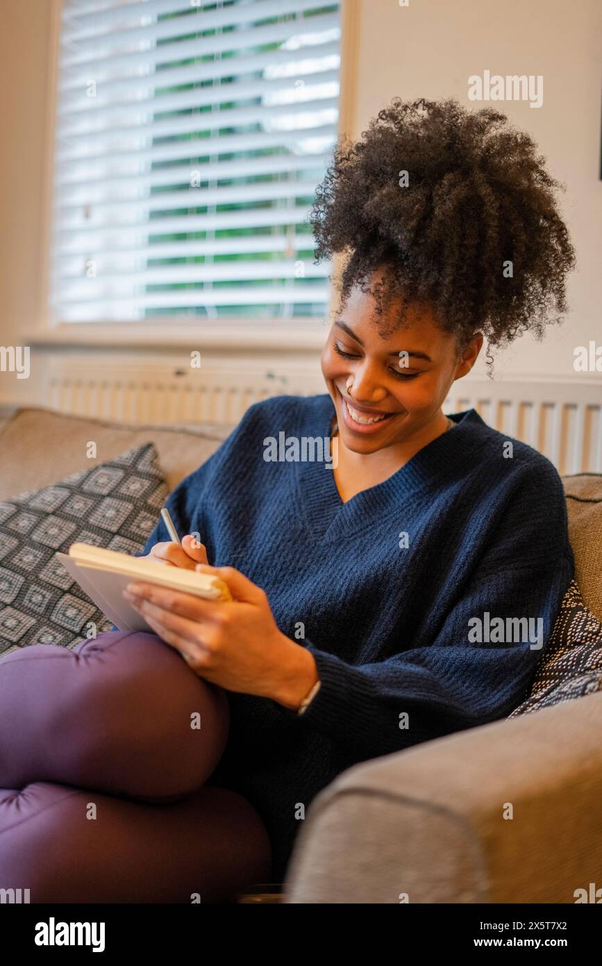 Young african woman writing in hi-res stock photography and images - Alamy