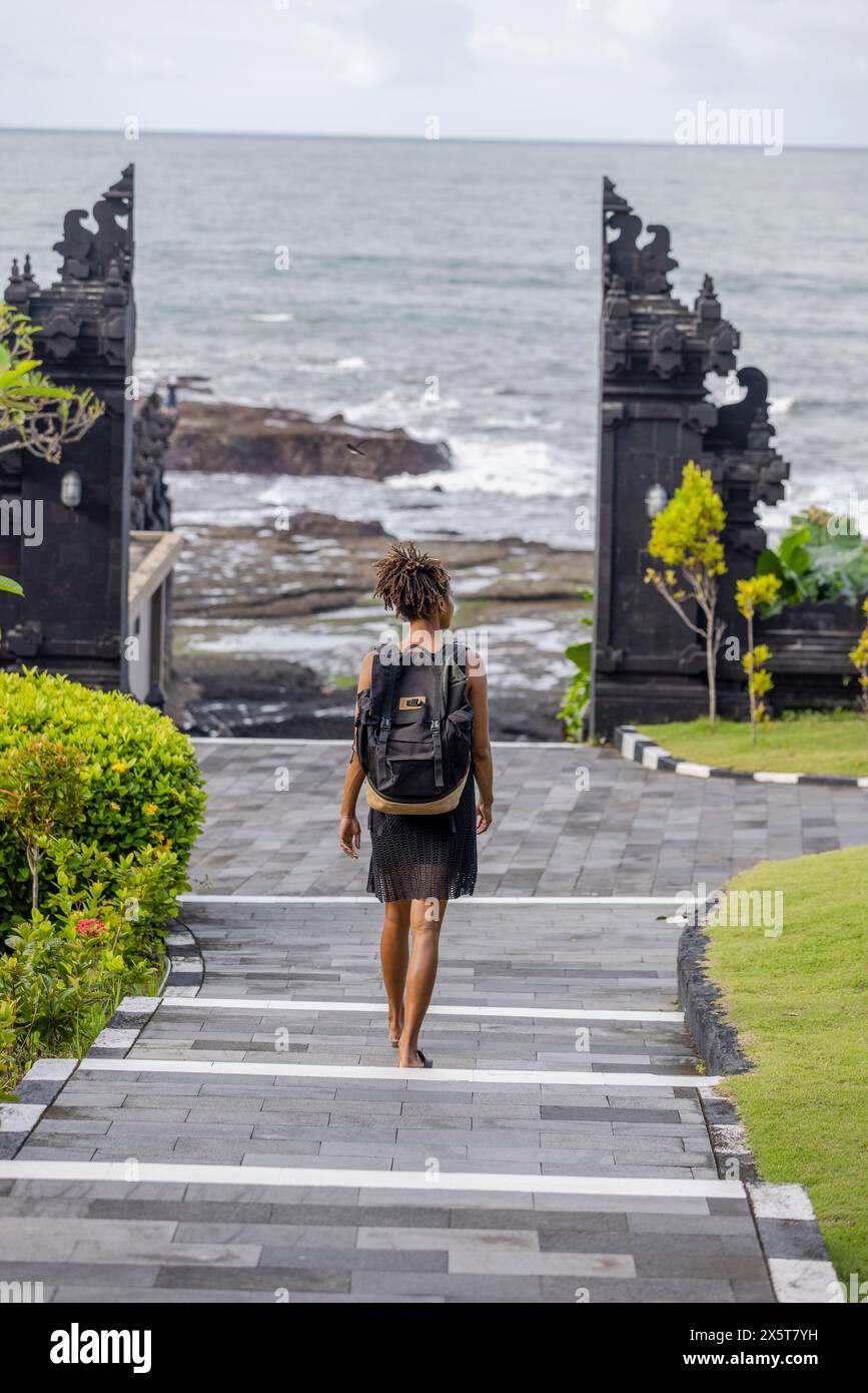 Bali, Indonesia, Rear view of female tourist walking in sea direction Stock Photo