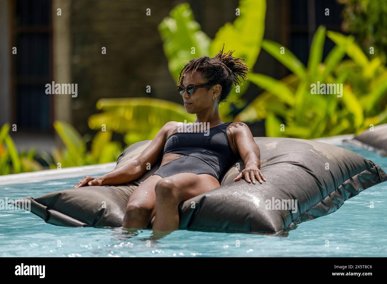 Indonesia, Bali, Woman relaxing in swimming pool Stock Photo