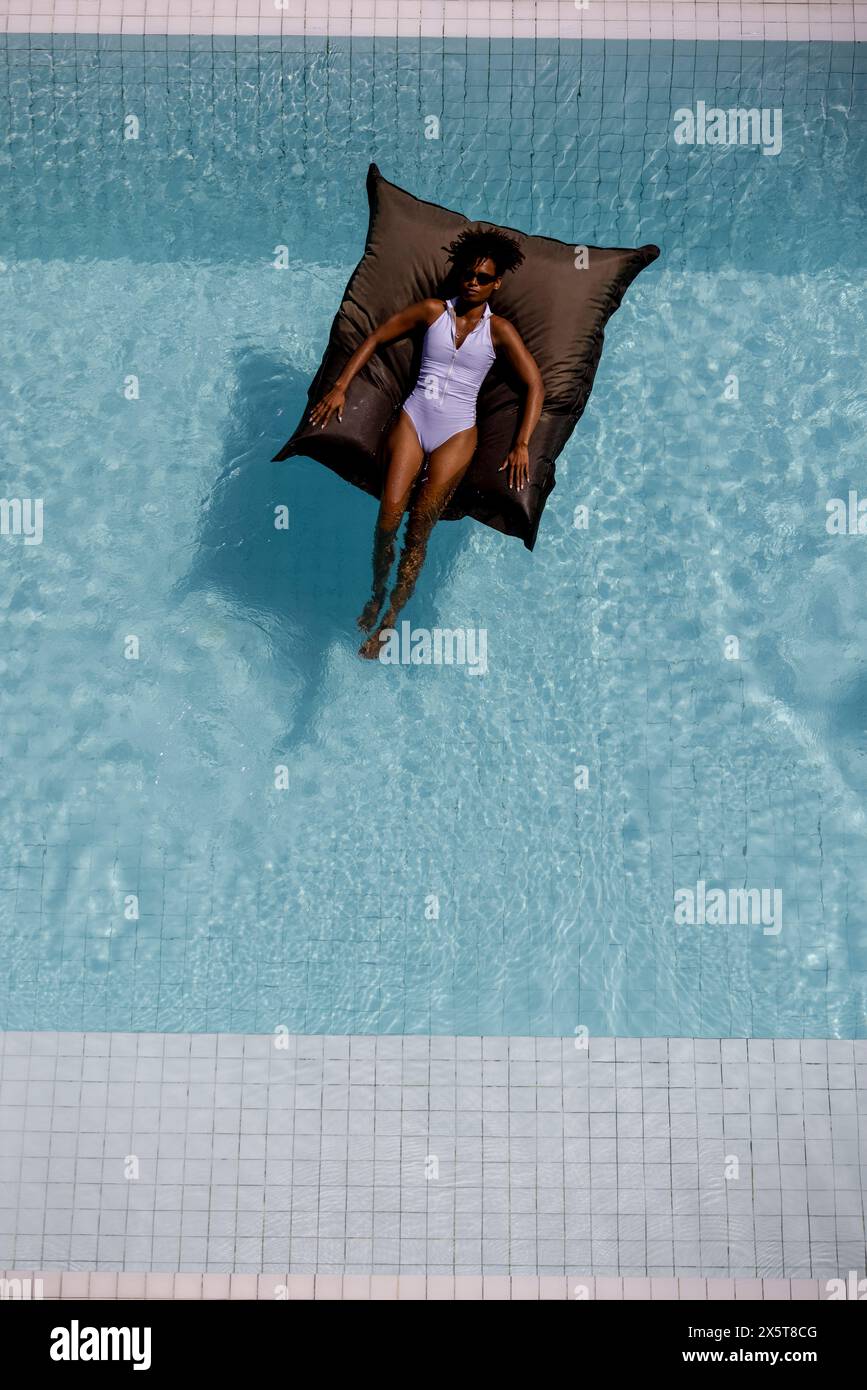 Overhead view of woman relaxing in swimming pool Stock Photo