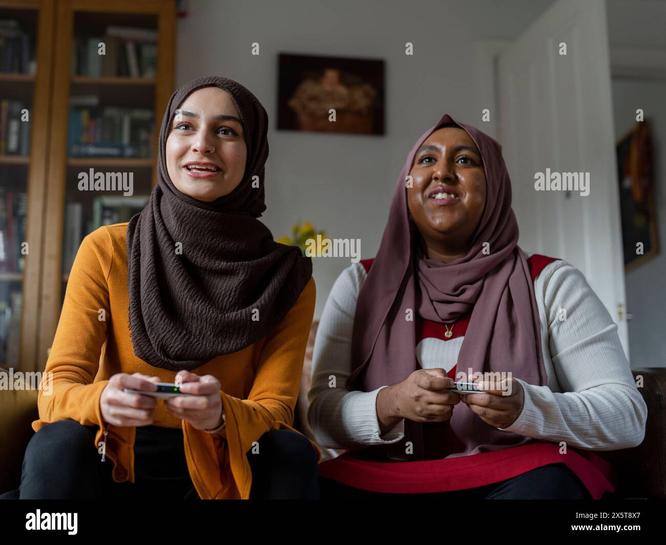 Women playing video game at home Stock Photo
