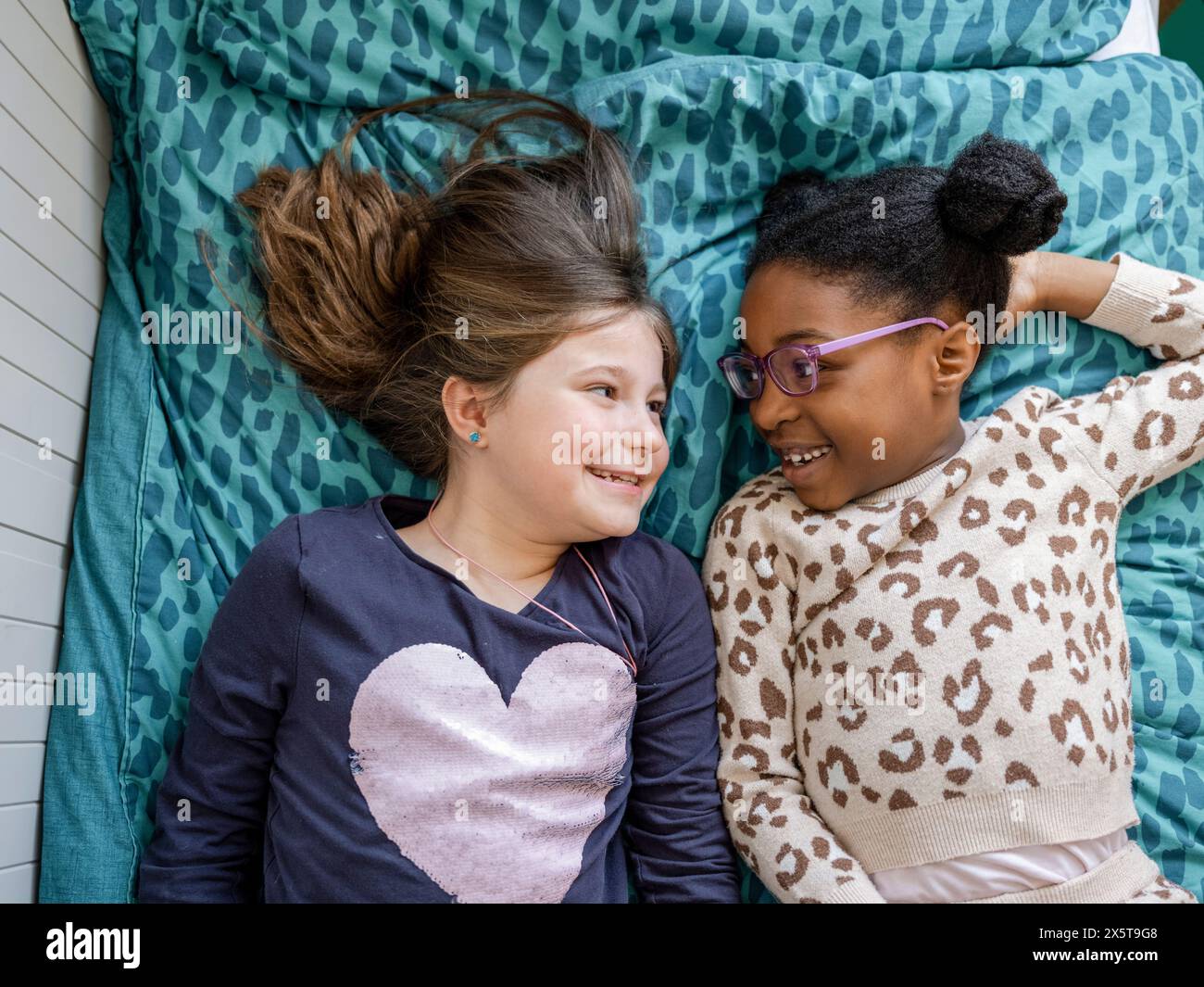 Two girls lying on bed hi-res stock photography and images - Alamy