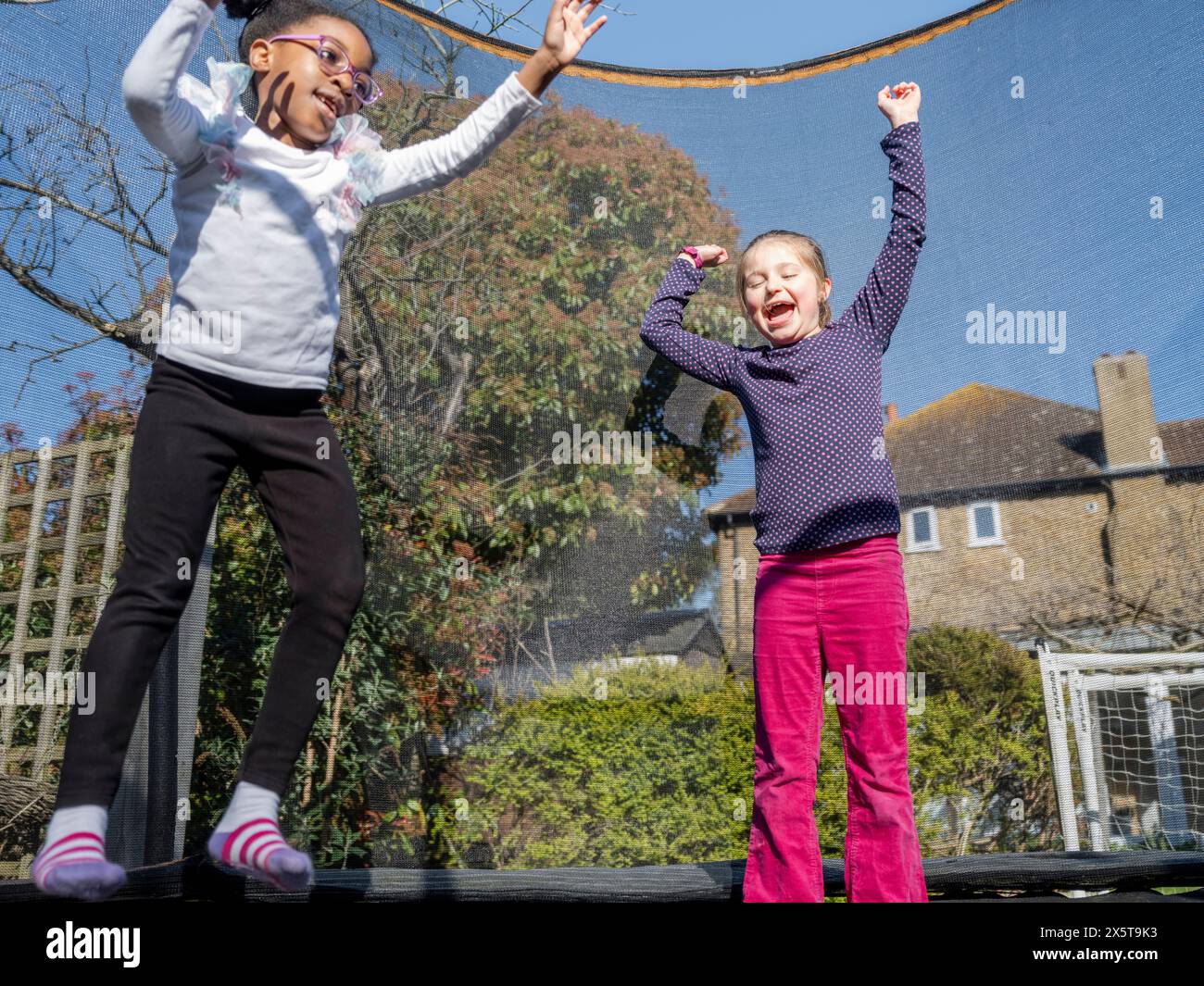 Two girls jumping on trampoline hi-res stock photography and images - Alamy