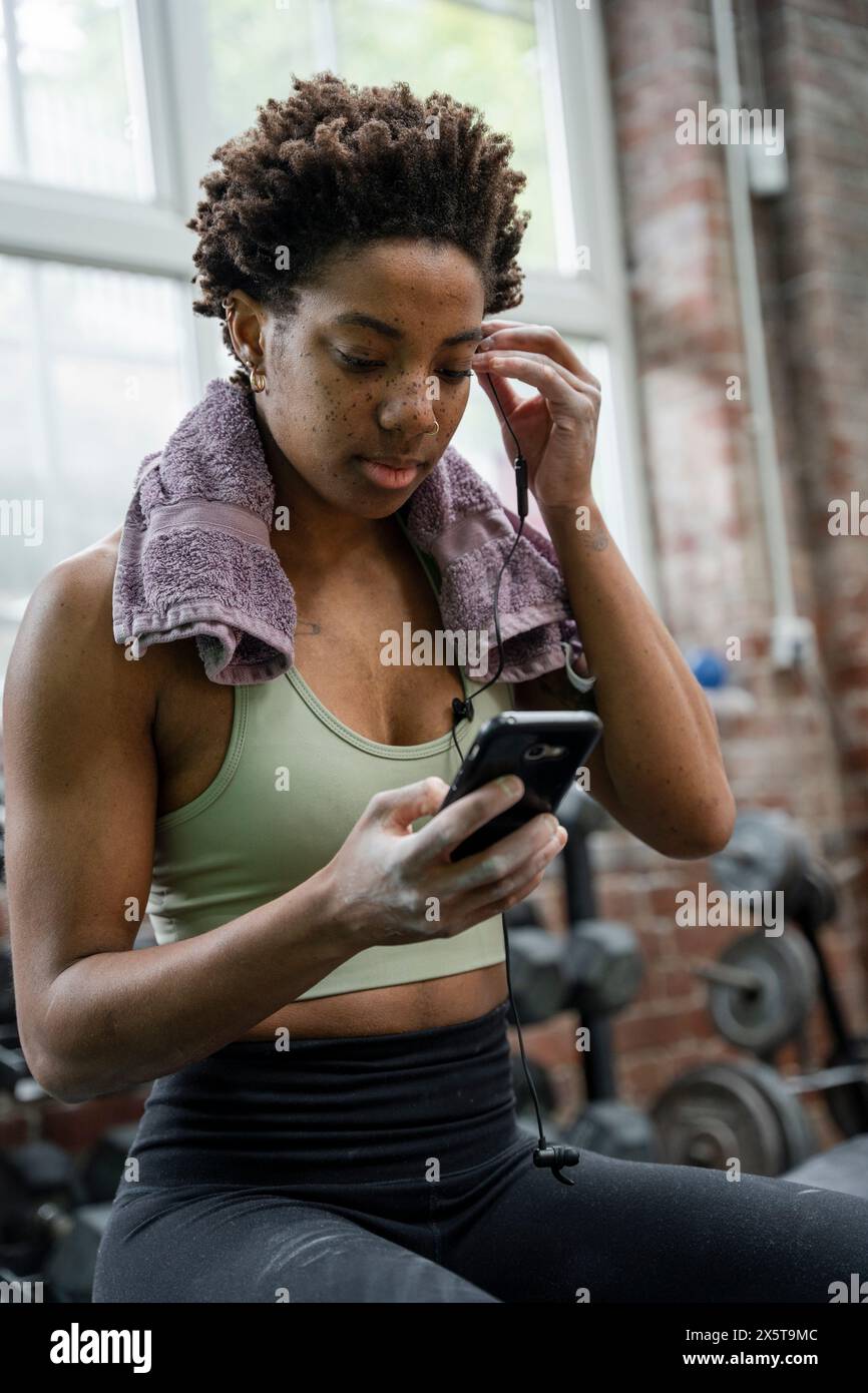 Woman using phone during training on gym Stock Photo