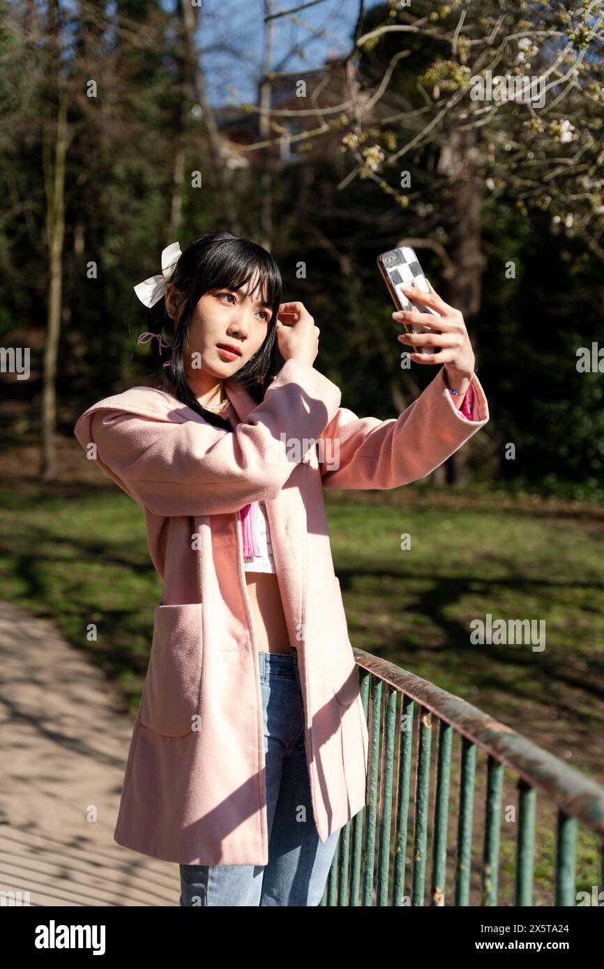 Woman adjusting hair in park hi-res stock photography and images - Alamy