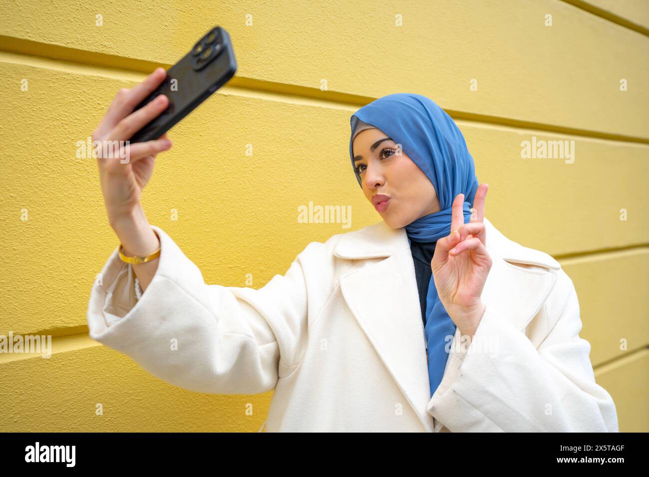 Young woman wearing hijab yellow hi-res stock photography and images ...