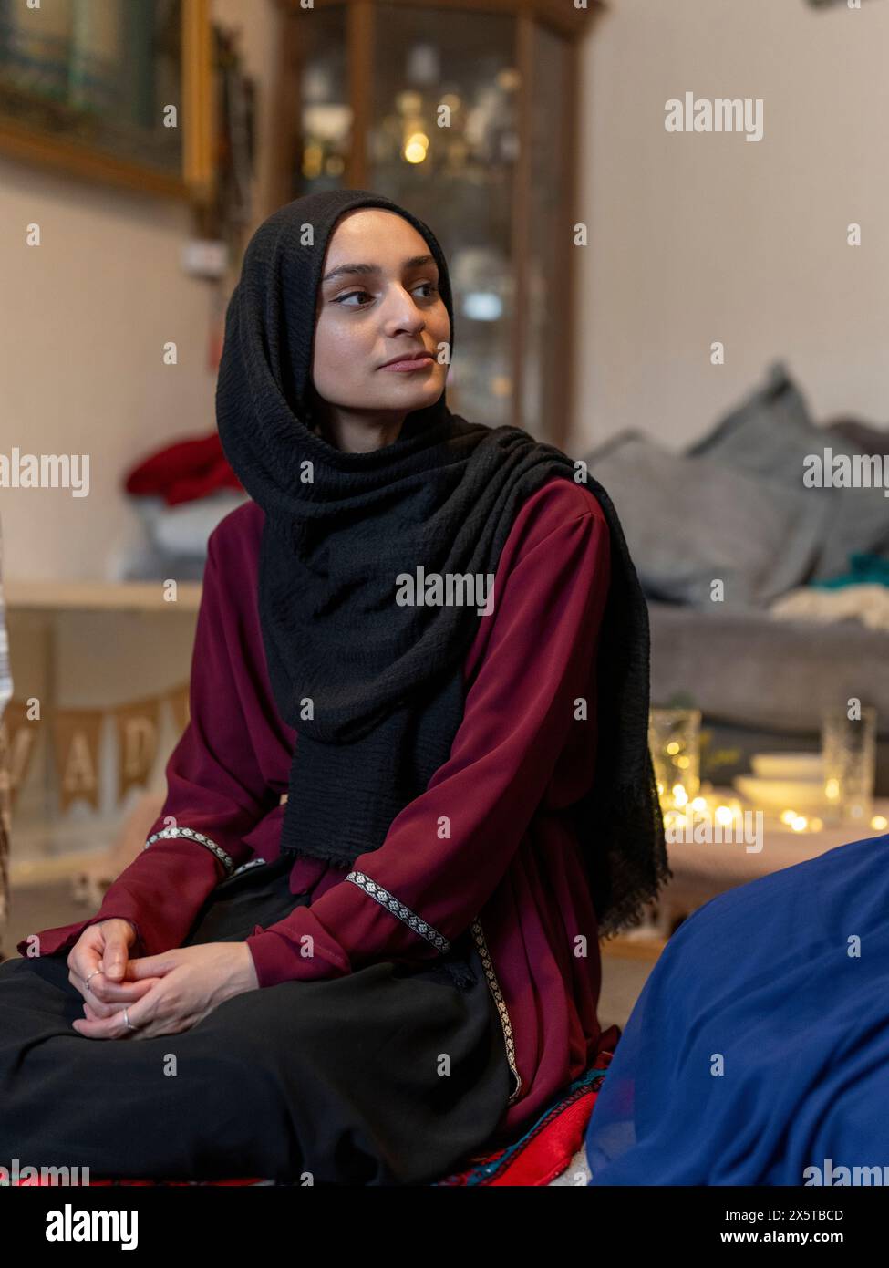 Woman kneeling during Ramadan at home Stock Photo