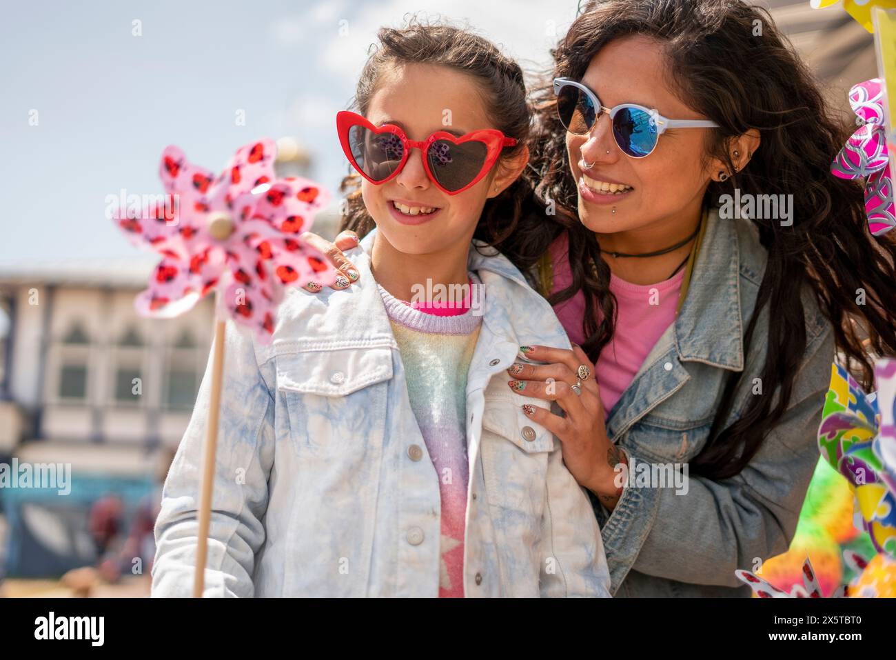 Smiling mother and daughter (8-9) playing with pinwheel Stock Photo - Alamy
