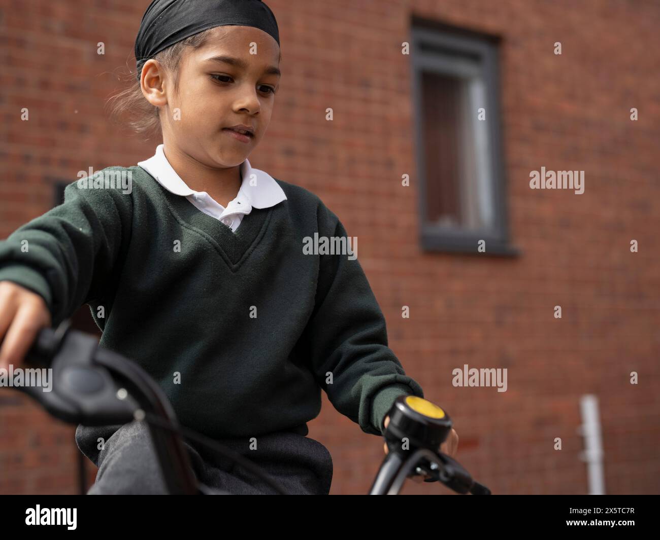 Boy (6-7) in school uniform riding bicycle Stock Photo