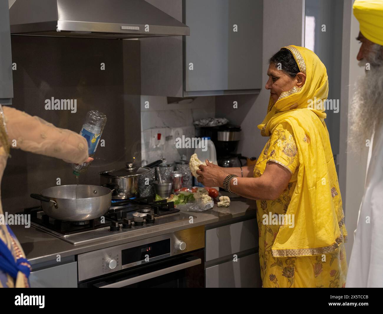 Family in traditional clothing cooking meal together Stock Photo