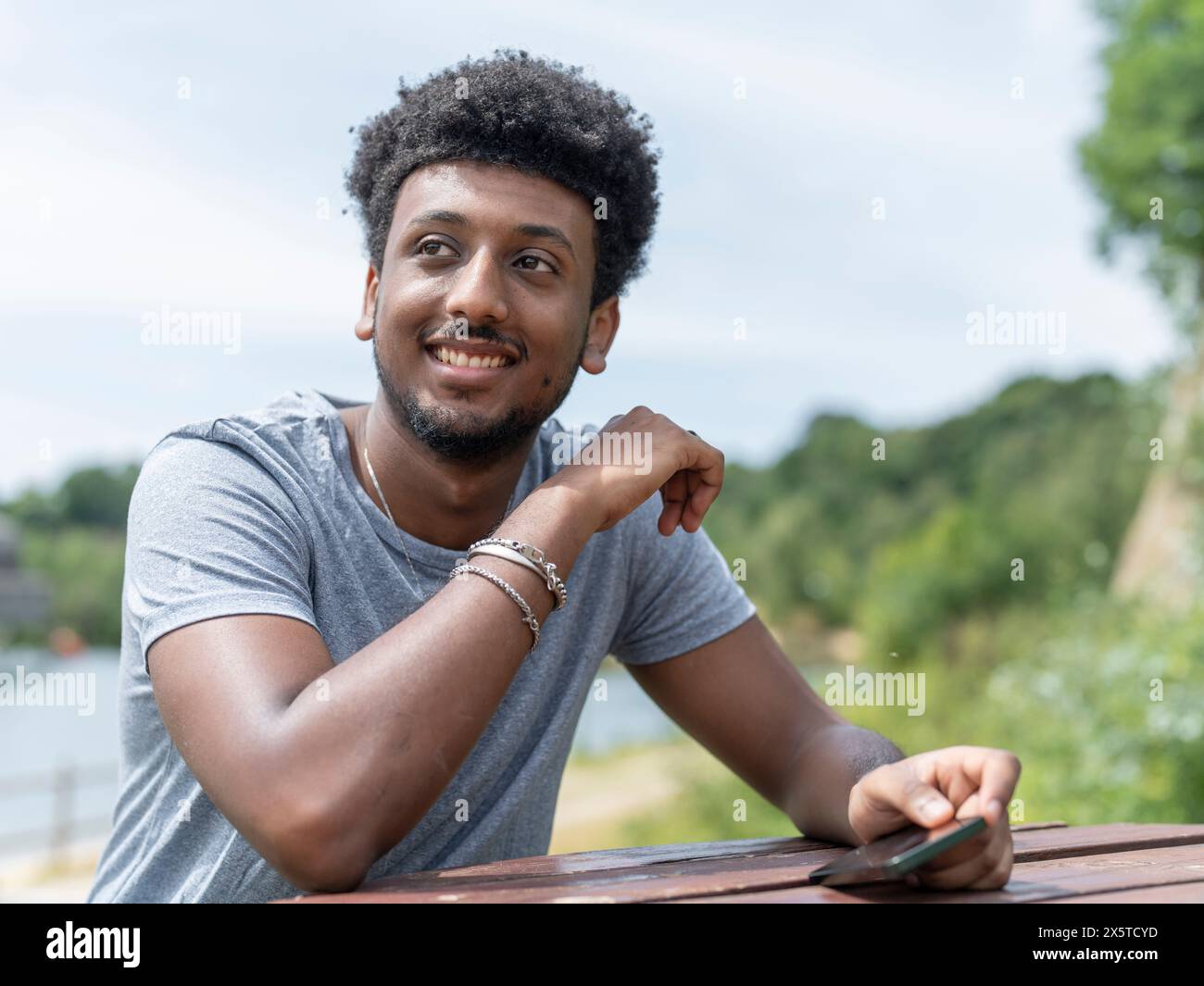 Young man sitting picnic table hi-res stock photography and images - Alamy