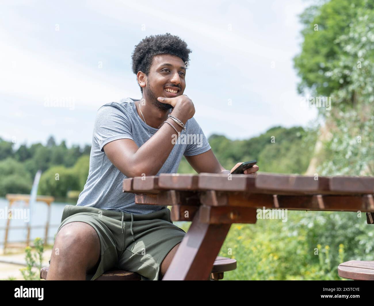 Young man sitting picnic table hi-res stock photography and images - Alamy
