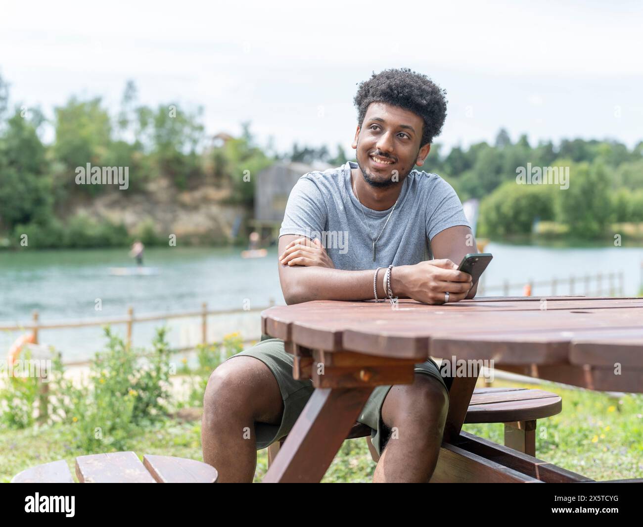 Young man sitting picnic table hi-res stock photography and images - Alamy