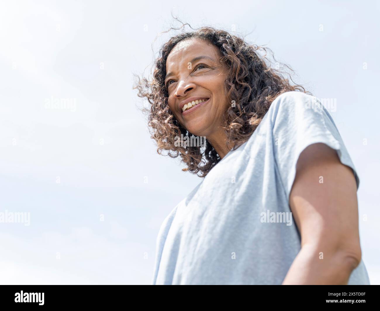Portrait of smiling woman against sky Stock Photo