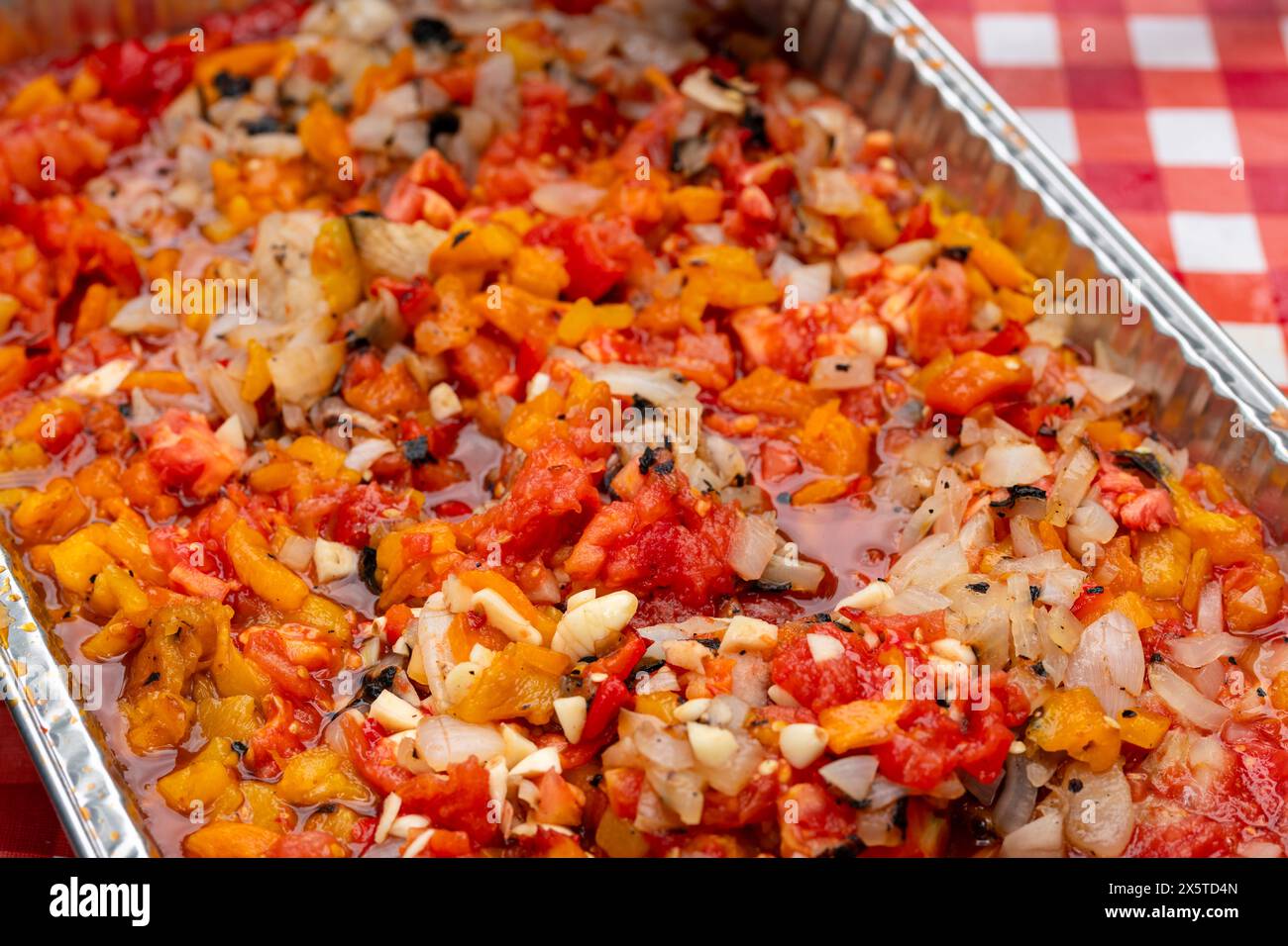 Roasted salsa with spices, peppers, onions, garlic, and tomatoes in an aluminum steam table pan. Party catering concept. Stock Photo