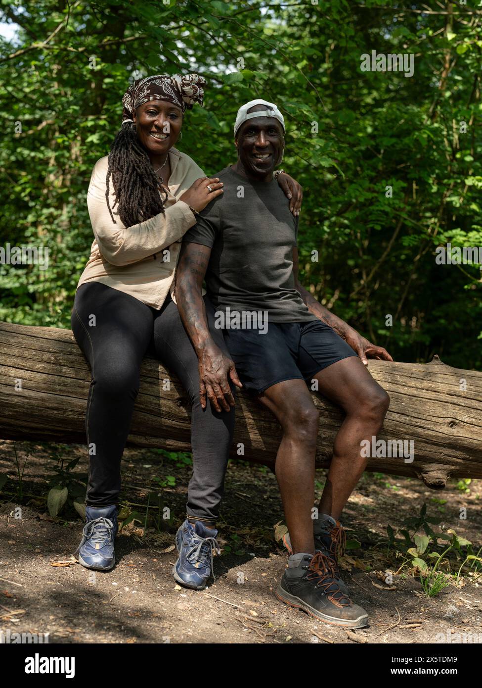 Portrait of mature couple sitting on log on hike Stock Photo