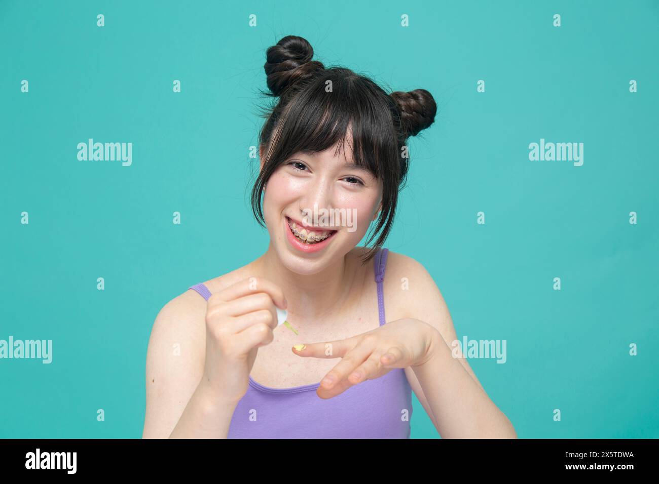 Studio portrait of smiling girl painting nails Stock Photo - Alamy