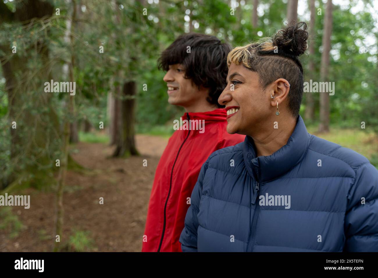 Smiling mother and son hiking in forest Stock Photo
