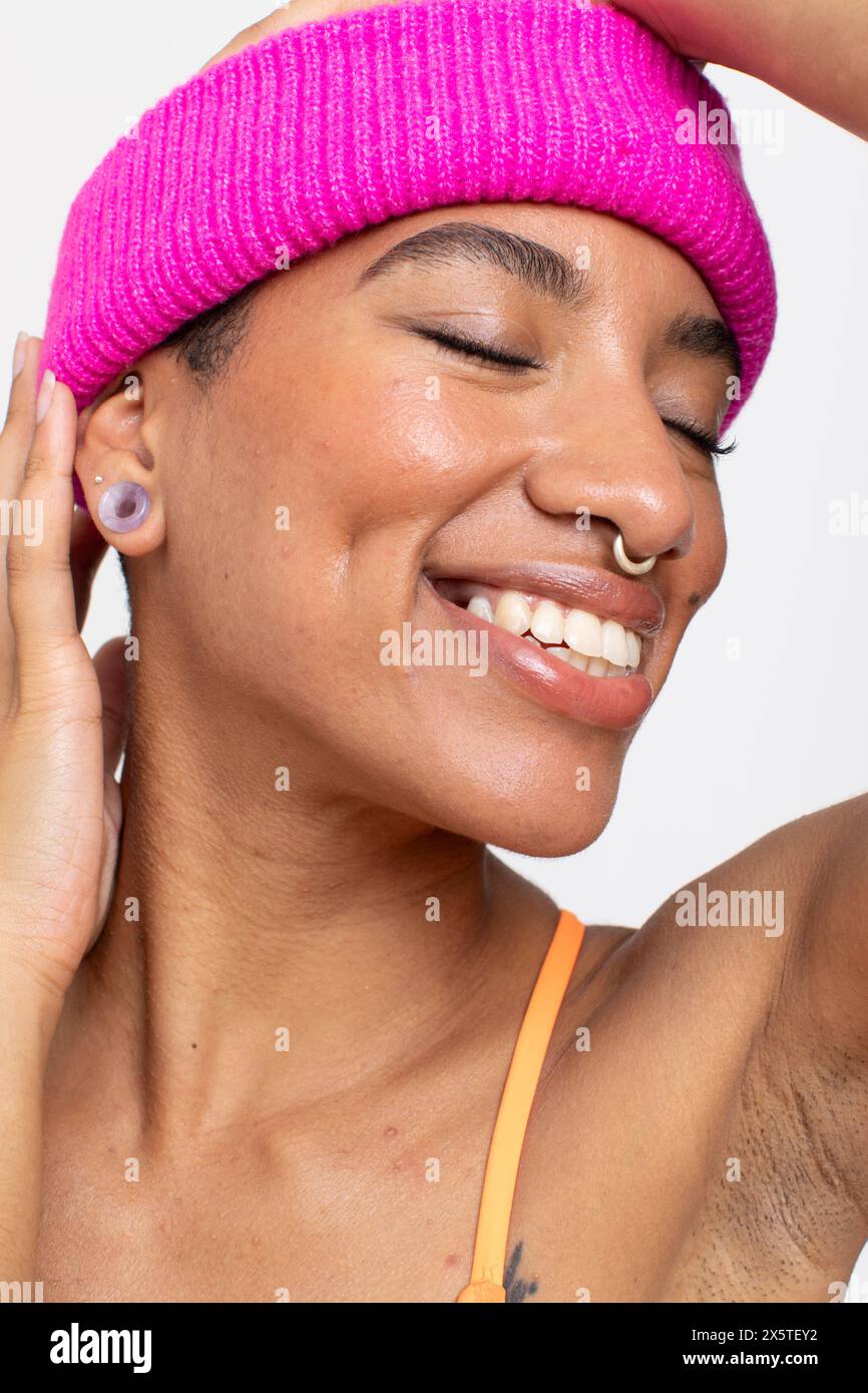 Studio portrait of smiling woman in pink woolen cap Stock Photo