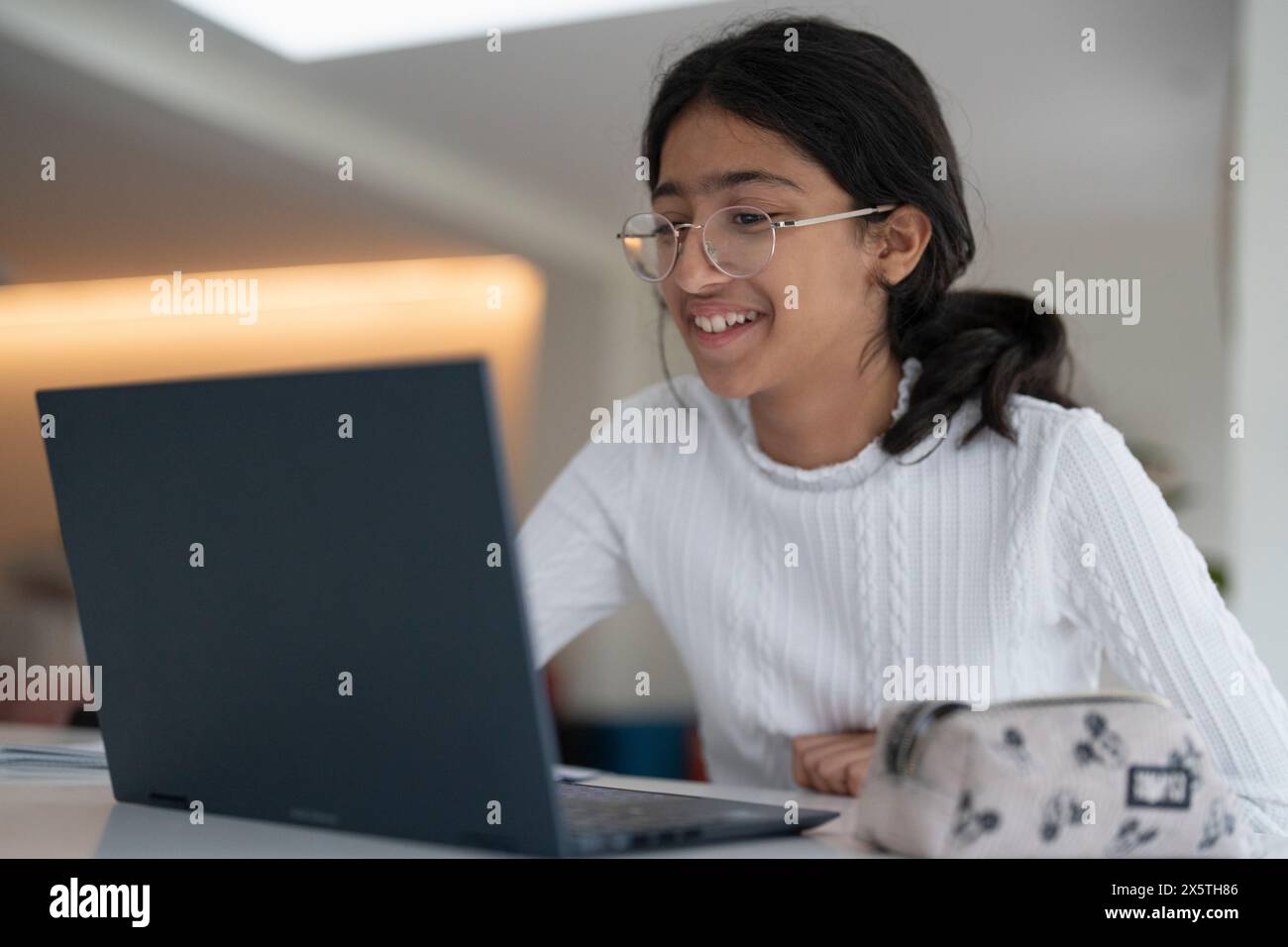 Schoolgirl doing homework using laptop Stock Photo - Alamy
