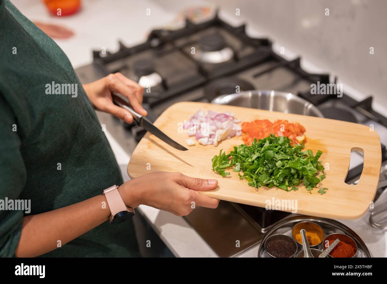 Woman holding cutting board with chopped vegetables Stock Photo