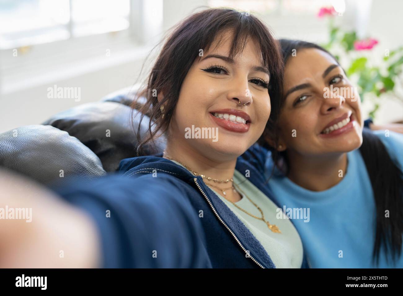 Two women sitting on sofa hi-res stock photography and images - Alamy
