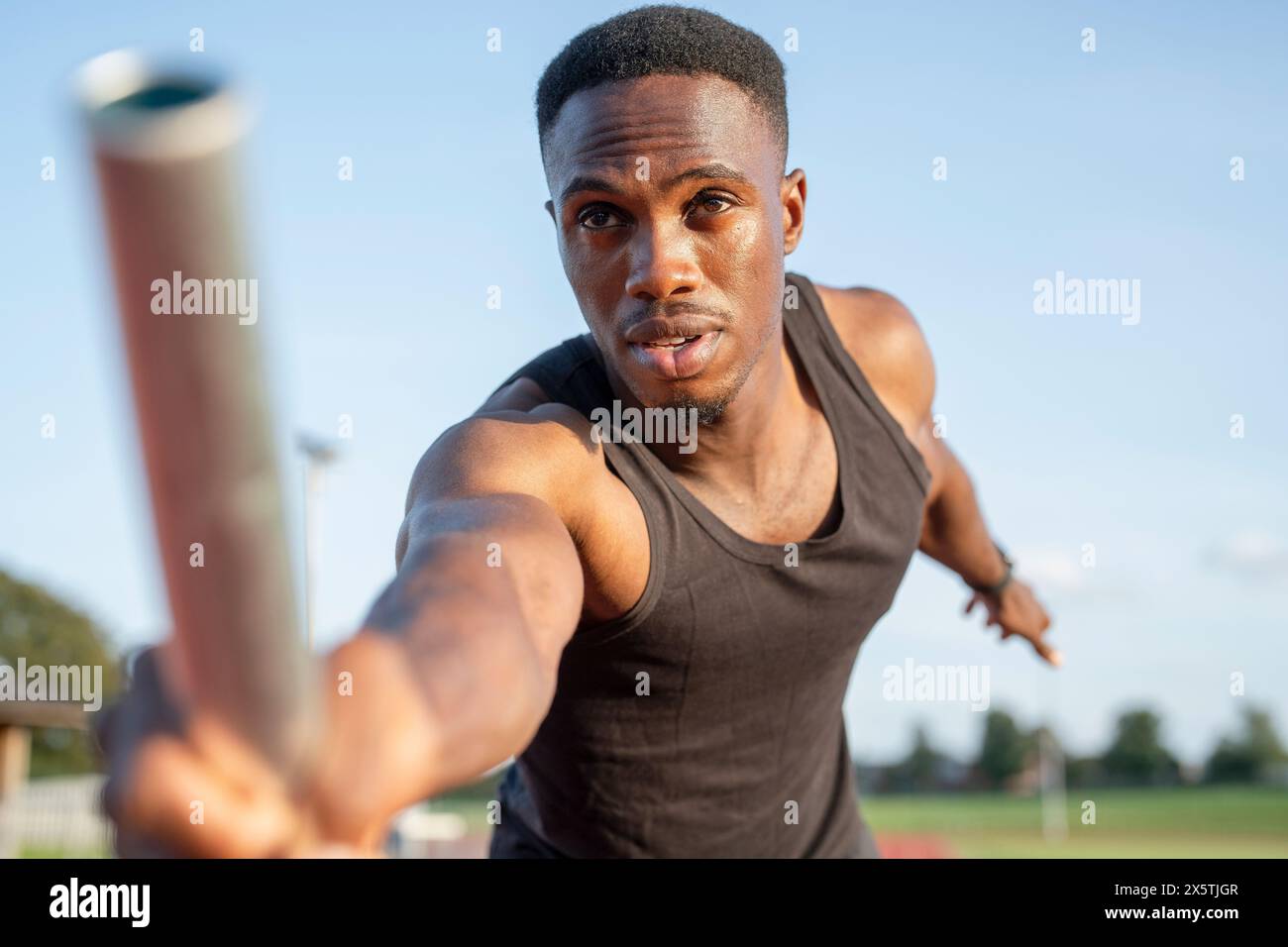 Athlete holding relay baton during race Stock Photo