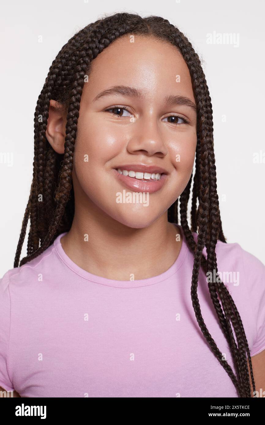 Studio portrait of smiling girl with braided hair Stock Photo - Alamy