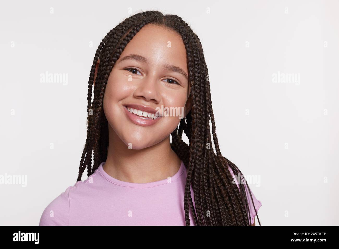 Studio portrait of smiling girl with braided hair Stock Photo - Alamy