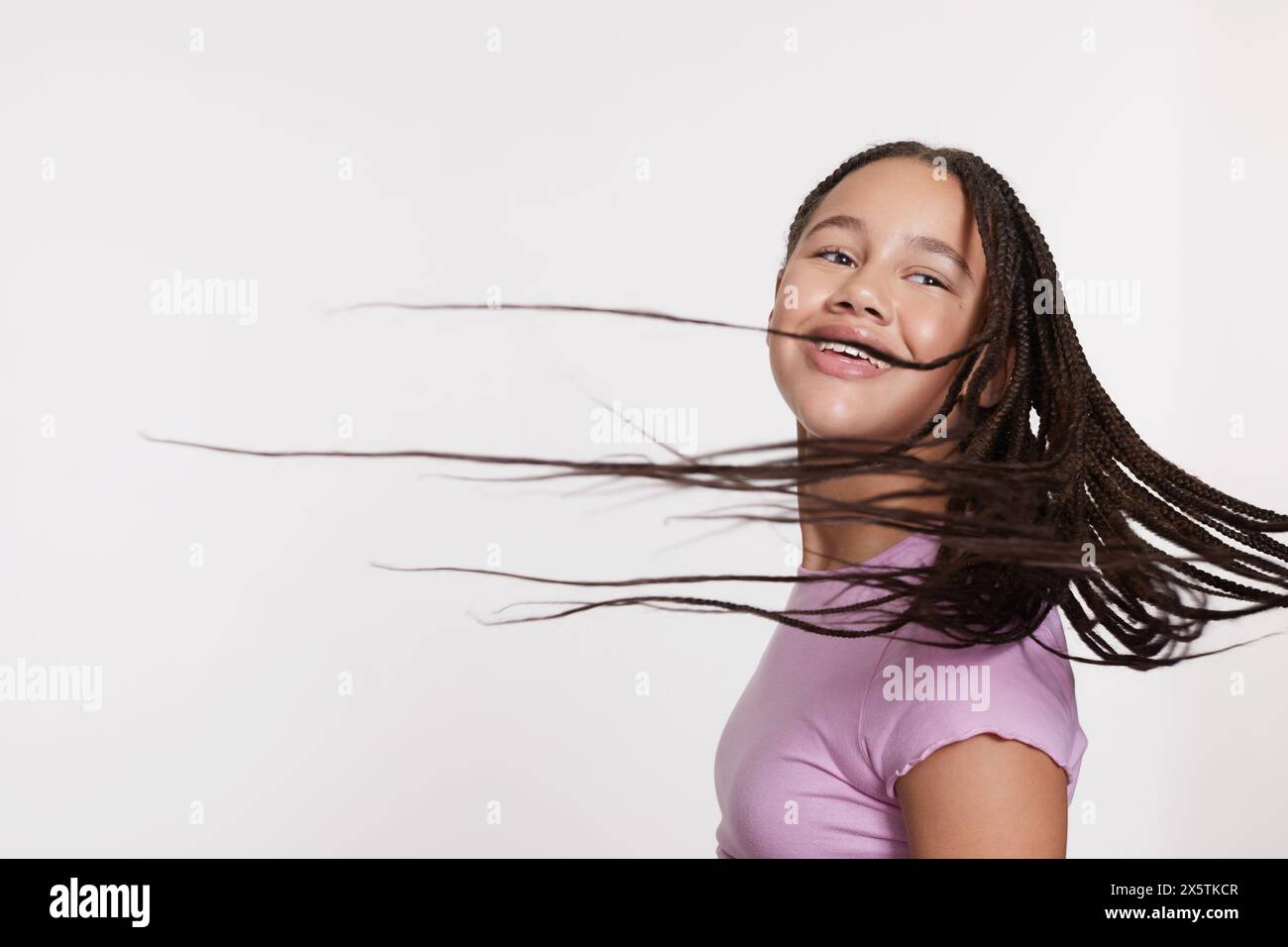 Studio portrait of smiling girl with long braided hair Stock Photo - Alamy