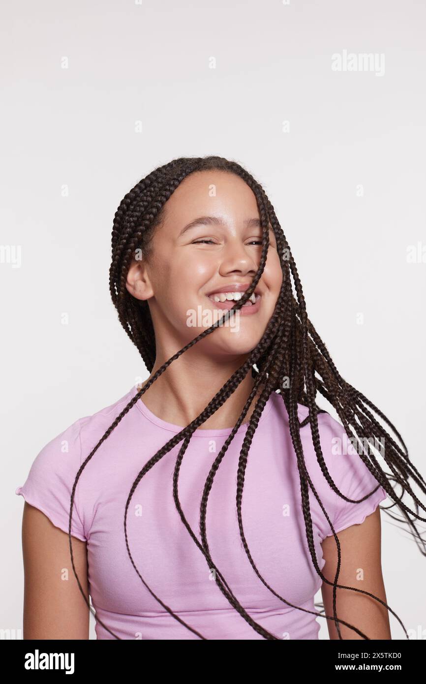 Studio portrait of smiling girl with long braided hair Stock Photo - Alamy