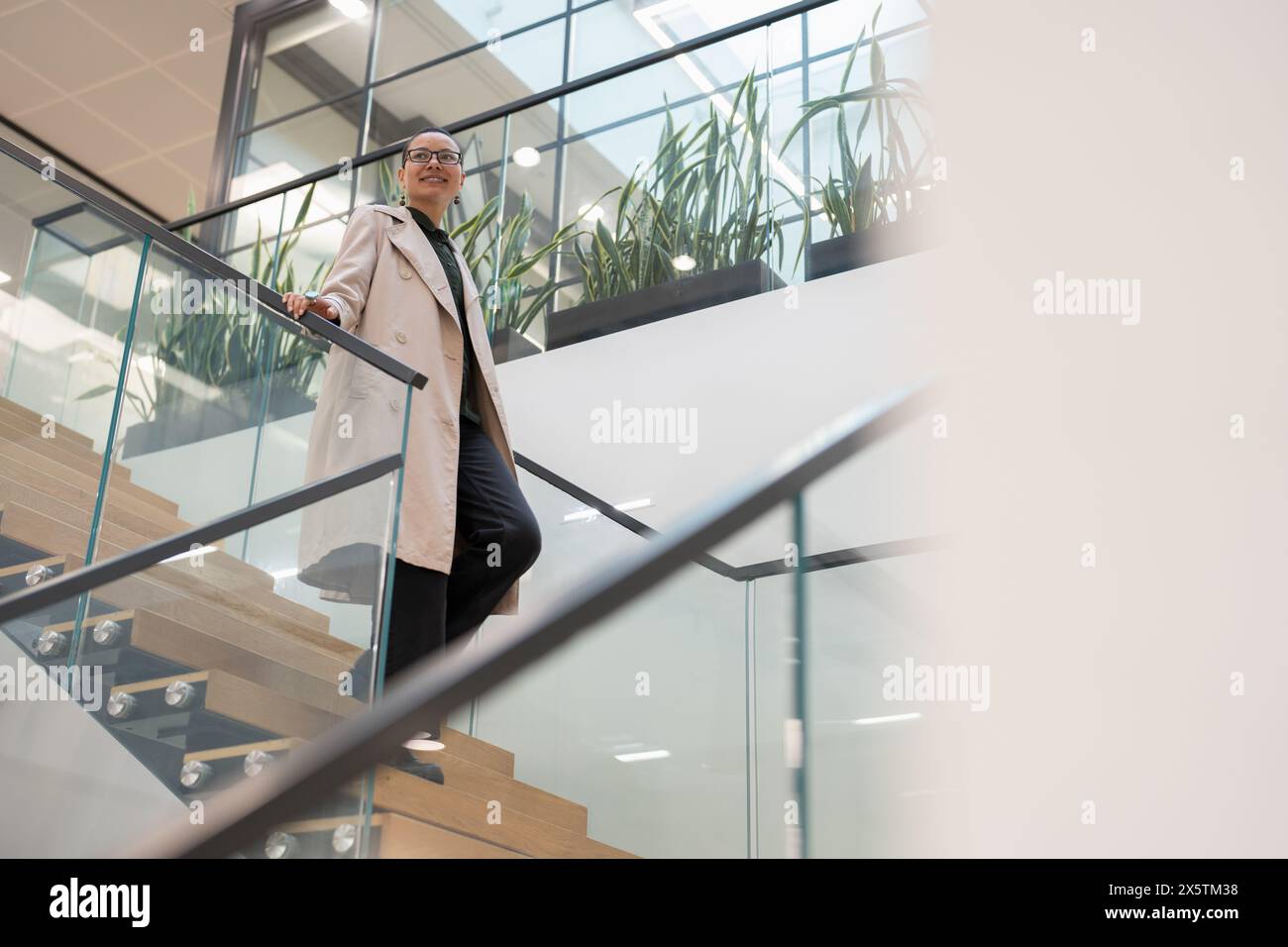 Non binary office worker walking on steps Stock Photo