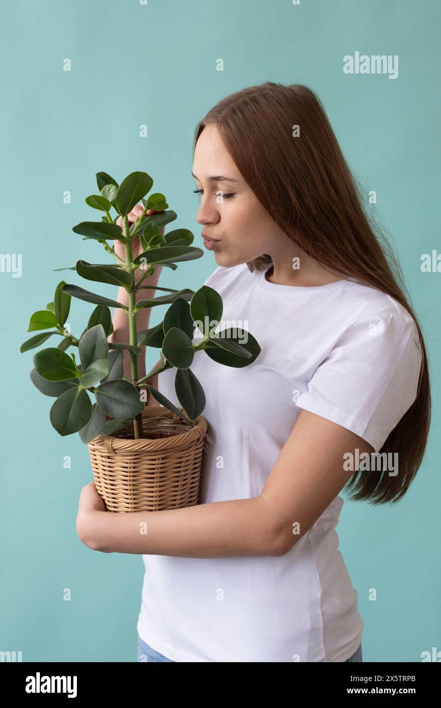 Studio portrait of teenage girl holding potted plant Stock Photo - Alamy