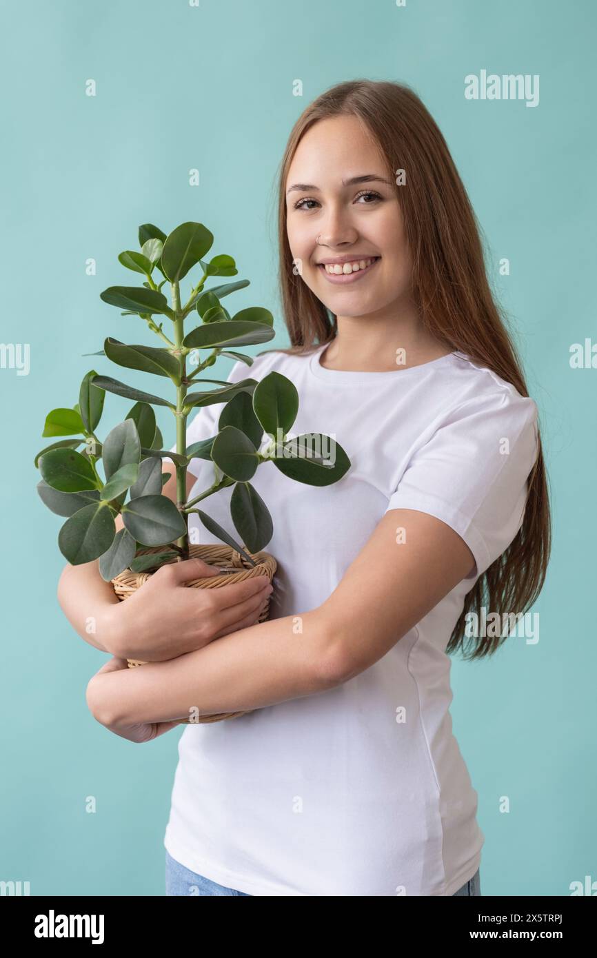 Studio portrait of smiling teenage girl holding potted plant Stock ...